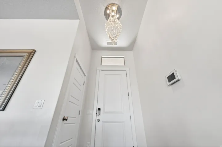 Entry foyer featuring a crystal chandelier, transom window, and a paneled door