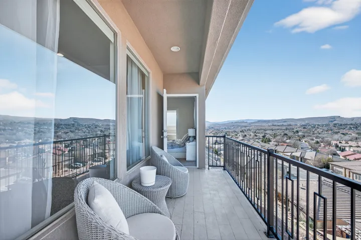 Balcony with a tile-finish floor, black metal railing, and direct access to an interior room