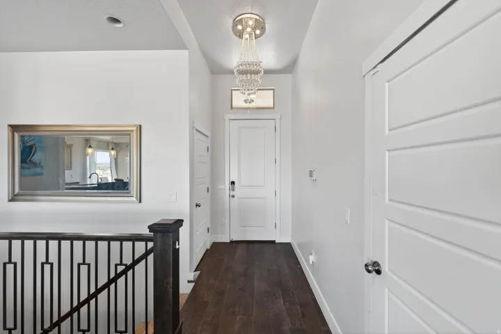 Hardwood-finish flooring, white panel doors, and a crystal chandelier