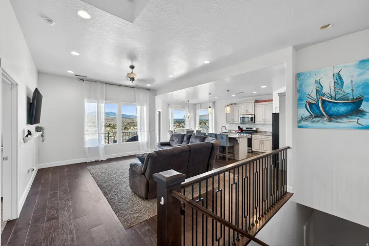Open concept living space with dark wood-finish flooring, recessed lighting, and large windows