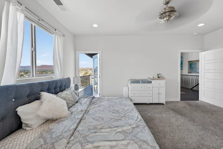 Large window, recessed lighting, ceiling fan, carpet flooring, balcony access