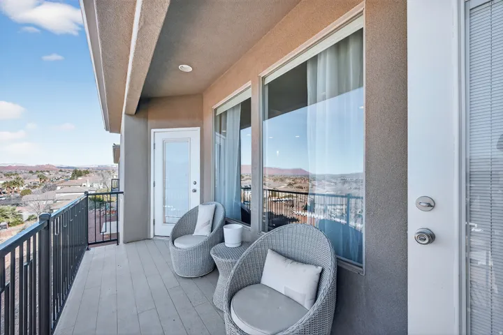 Balcony with a durable railing, exterior lighting, and a glass-paneled door