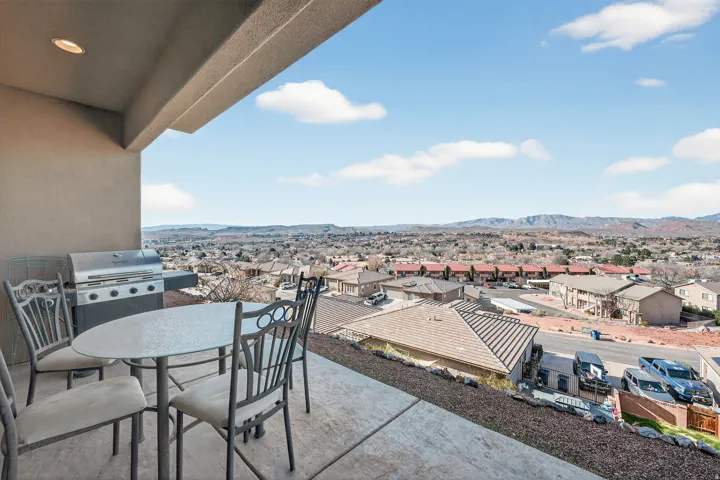 Covered outdoor patio with recessed lighting, concrete flooring, and surrounding cityscape