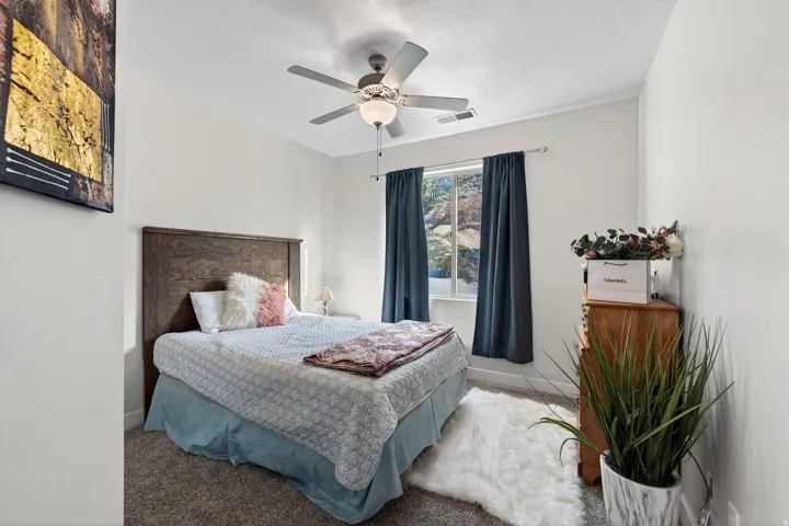 White walls with carpet flooring, complemented by a ceiling fan with integrated lighting