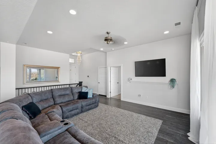 Open-concept living area featuring a vaulted ceiling with recessed lighting and a ceiling fan