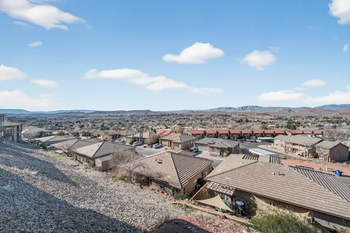 Expansive neighborhood with pitched roofs and distant mountain scenery