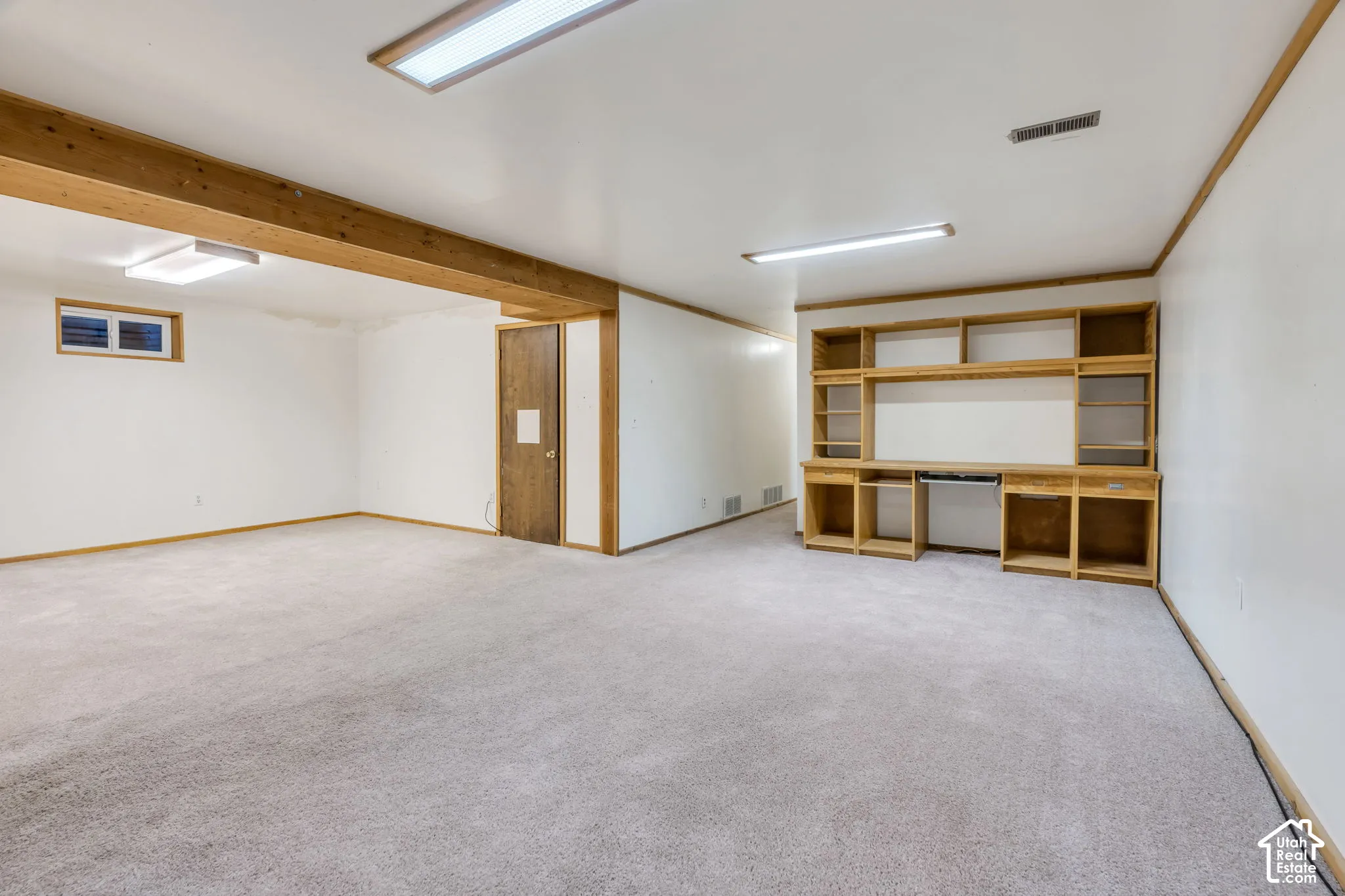 Spacious room with recessed lighting, and a built-in wood-finish shelving unit