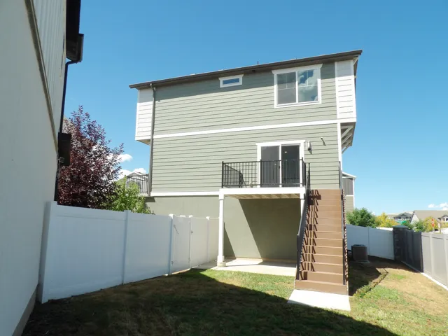 Two-story exterior with horizontal siding, upper-level window, and a deck with metal railings