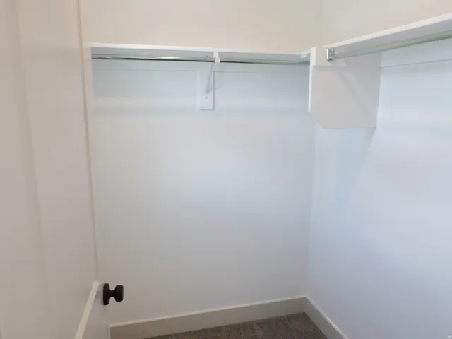 White painted walls with a built-in shelf and hanging rod