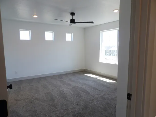 Recessed lighting, ceiling fan, multiple windows, and broadloom carpeting