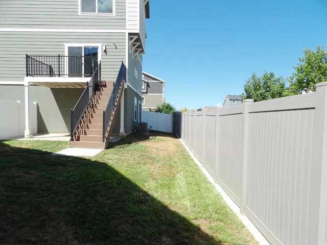 Elevated deck with black metal railing, sliding glass door, and exterior lighting