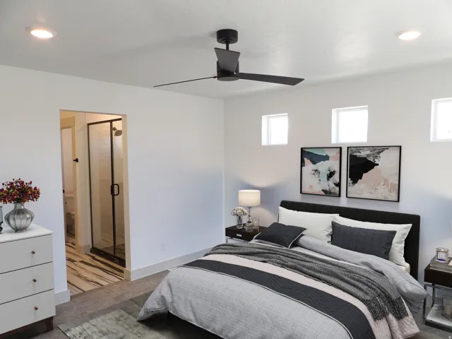 Ceiling fan with integrated lighting, recessed lighting, three high transom windows, and an en-suite bathroom with a glass-enclosed shower