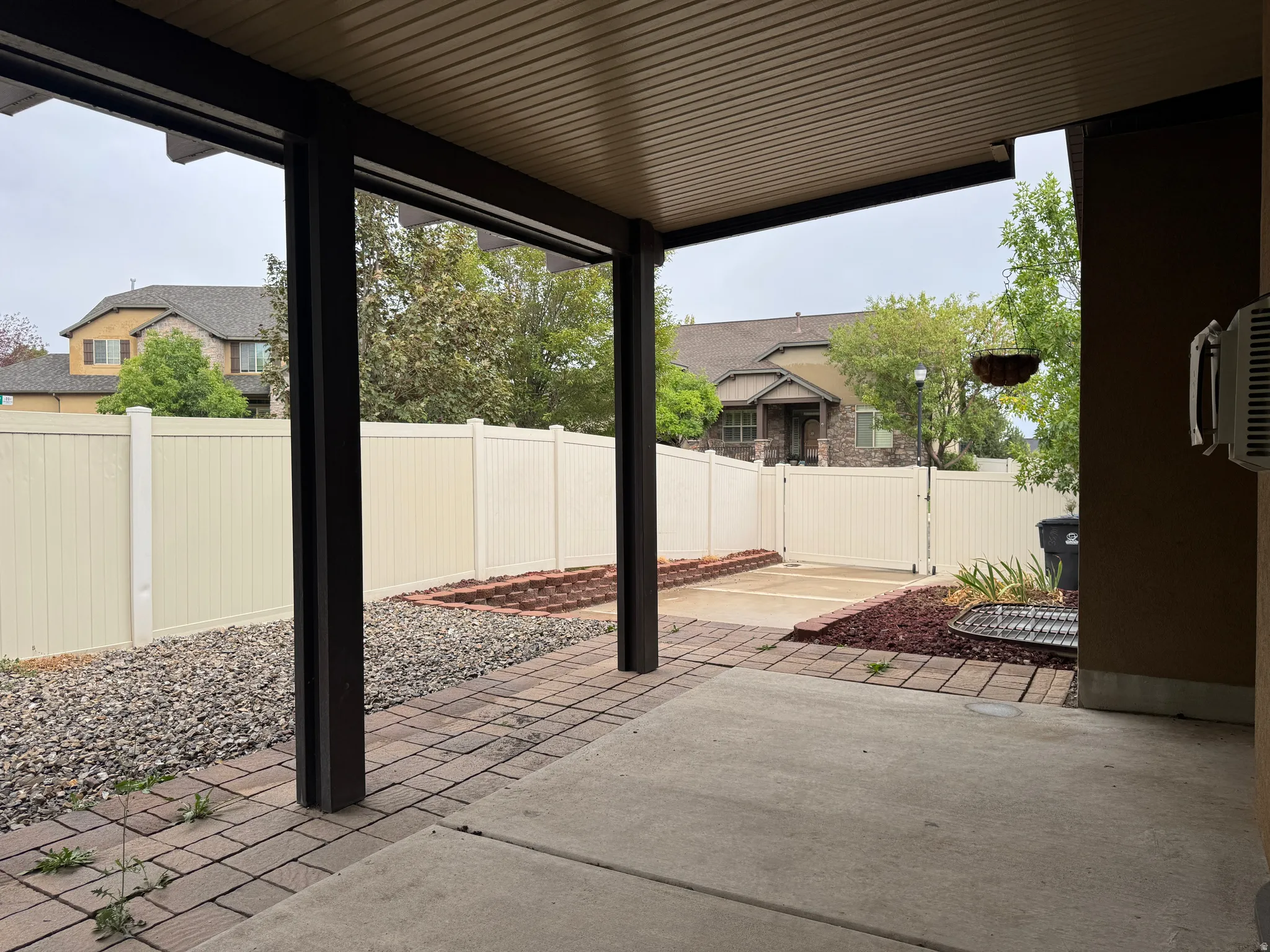 Covered patio with a concrete slab and brick paver accents