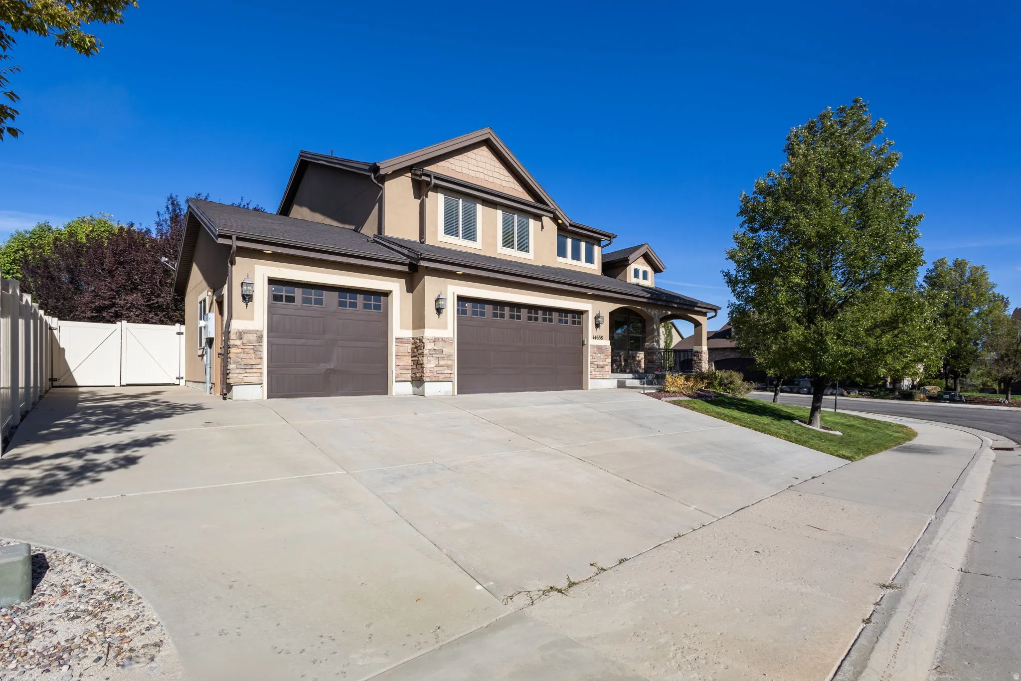 Stucco exterior with stone accents, attached two-car garage, covered entry, and a paved driveway