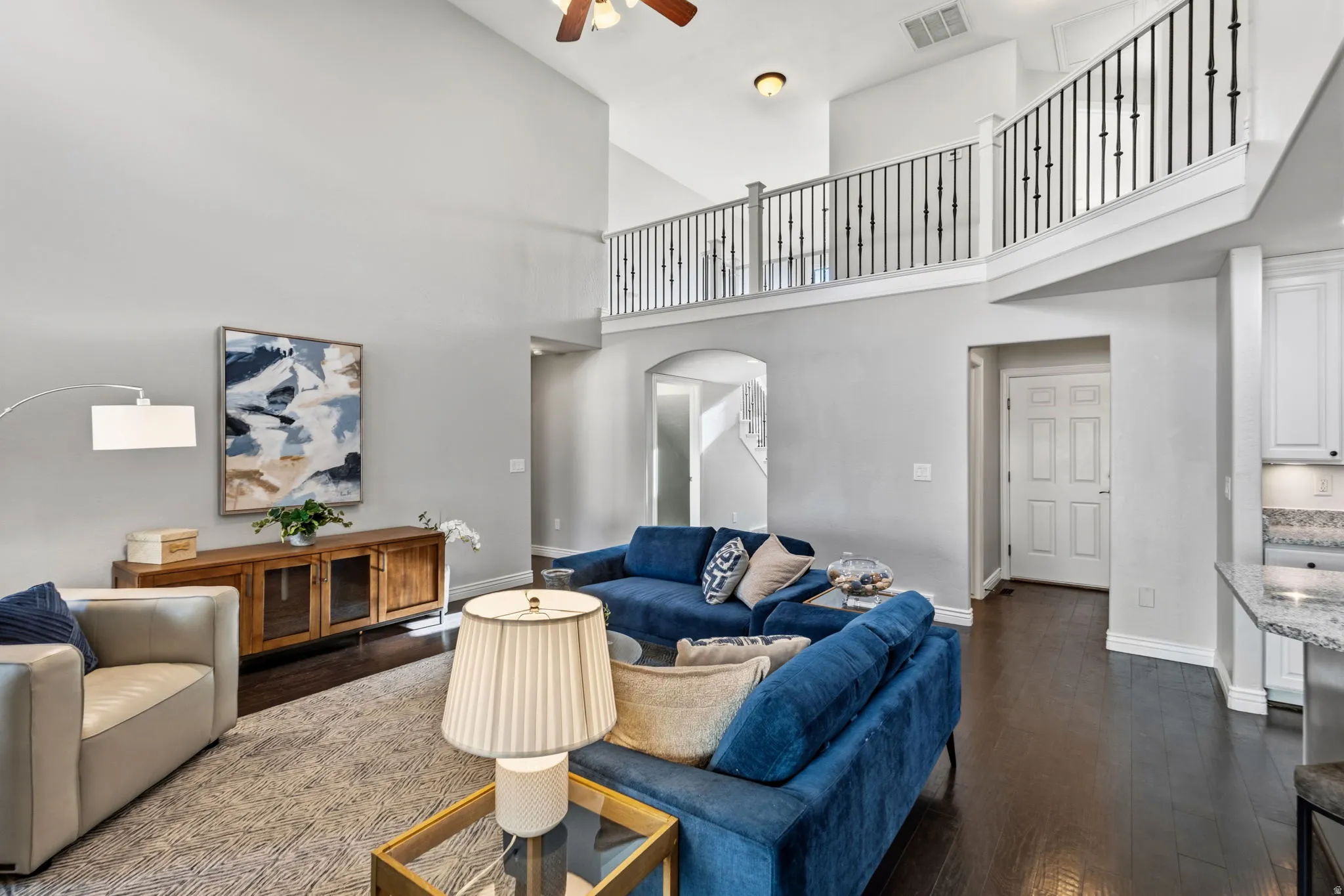 Vaulted ceiling living area with a dark wood-finish floor