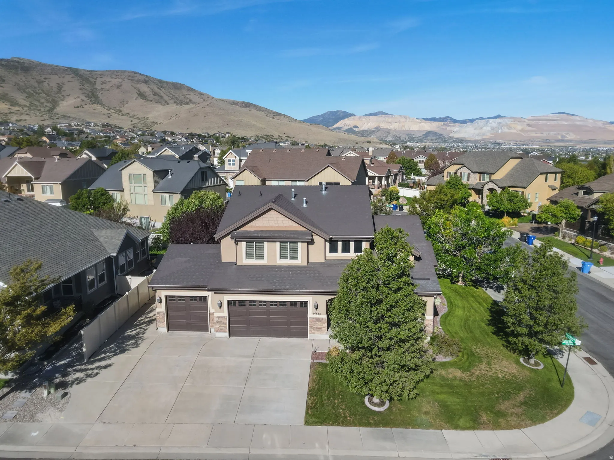 Mountain backdrop, two-car garage, concrete driveway, landscaped front yard, corner lot