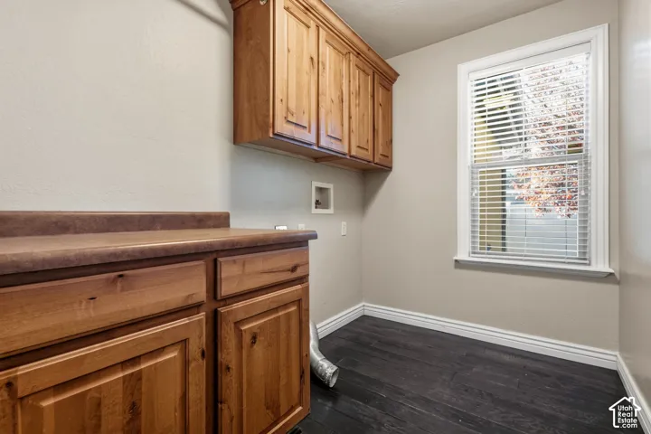 Wood-finish cabinetry with a contrasting countertop, wood-finish flooring, and natural light