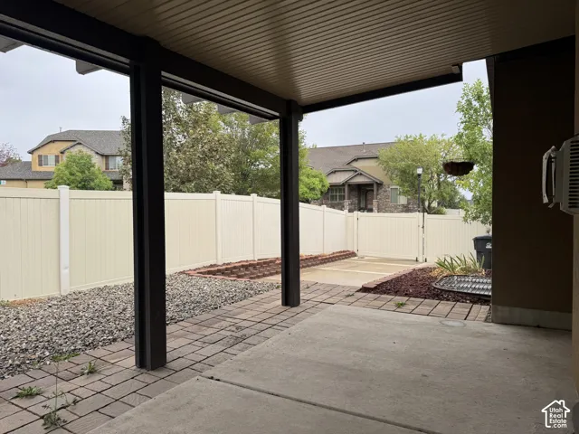 Covered patio with a concrete slab and brick paver accents