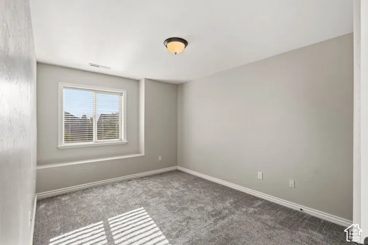 Carpeted flooring, recessed window, window blinds, ceiling-mounted light fixture, light-toned wall paint