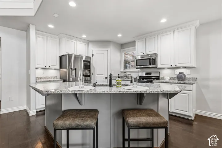 Kitchen featuring white cabinetry, light-toned countertops, recessed lighting, and stainless steel appliances