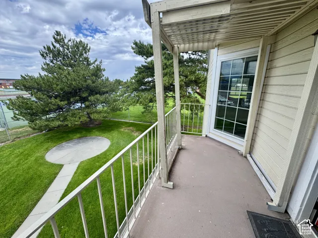 Covered balcony with metal railings and a grid-pattern window