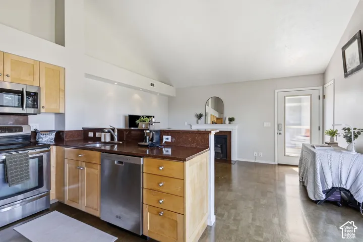 Kitchen with wood cabinetry, stainless steel appliances, and a built-in dishwasher