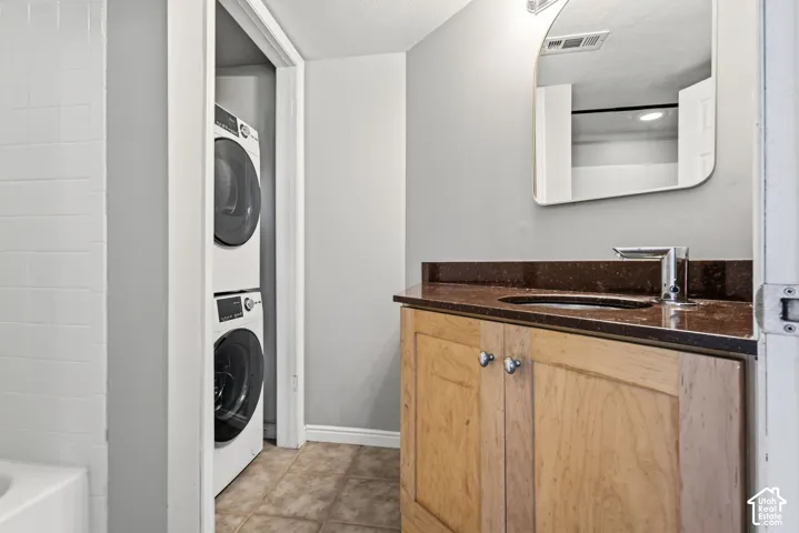 Wood-finish vanity with a built-in sink, brown countertop, and chrome faucet