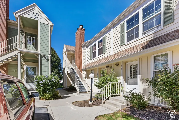 Multi-unit exterior with vertical siding and brick chimneys
