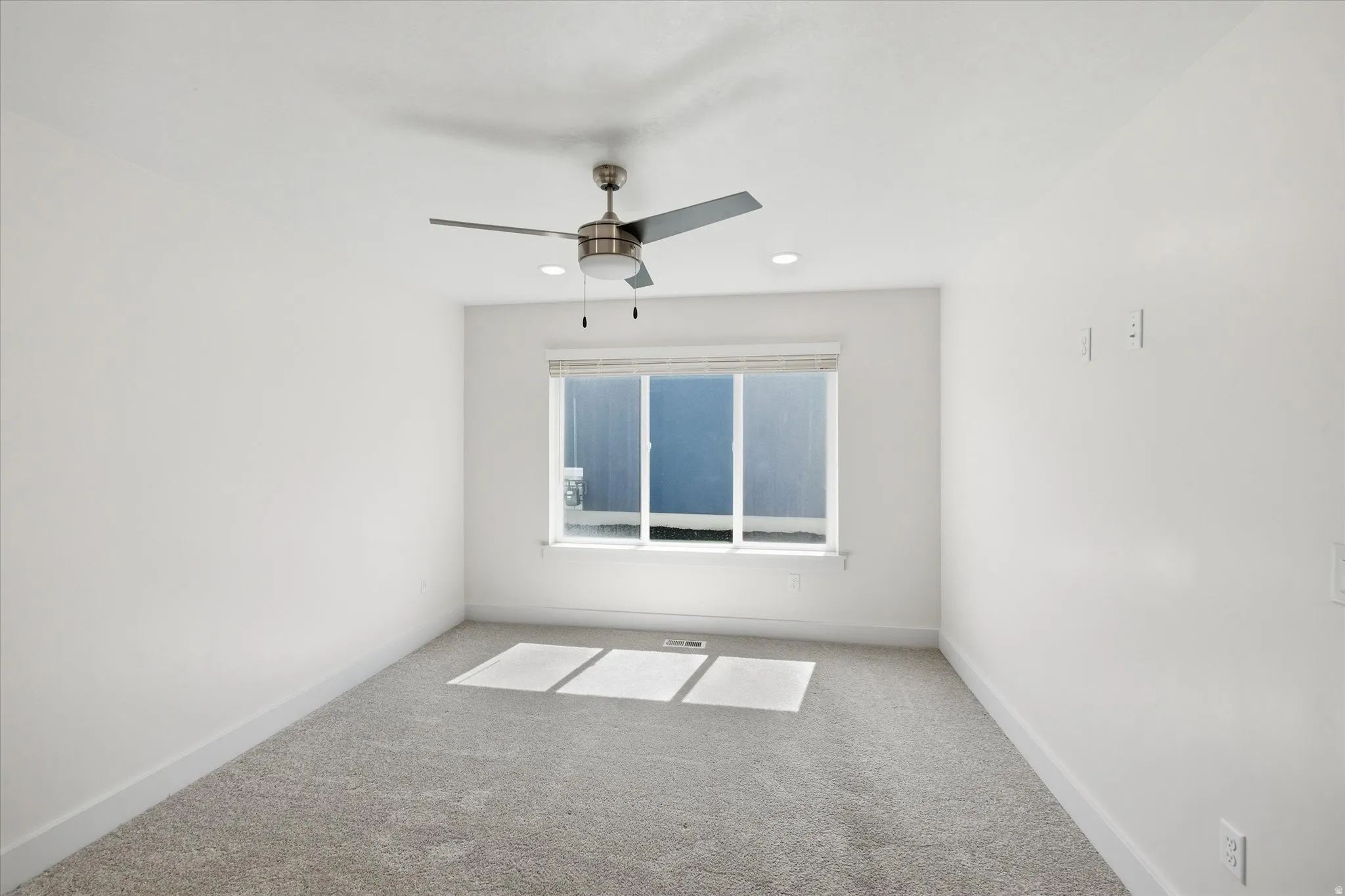 Recessed lighting, ceiling fan, window with blinds, light gray carpet, and white walls