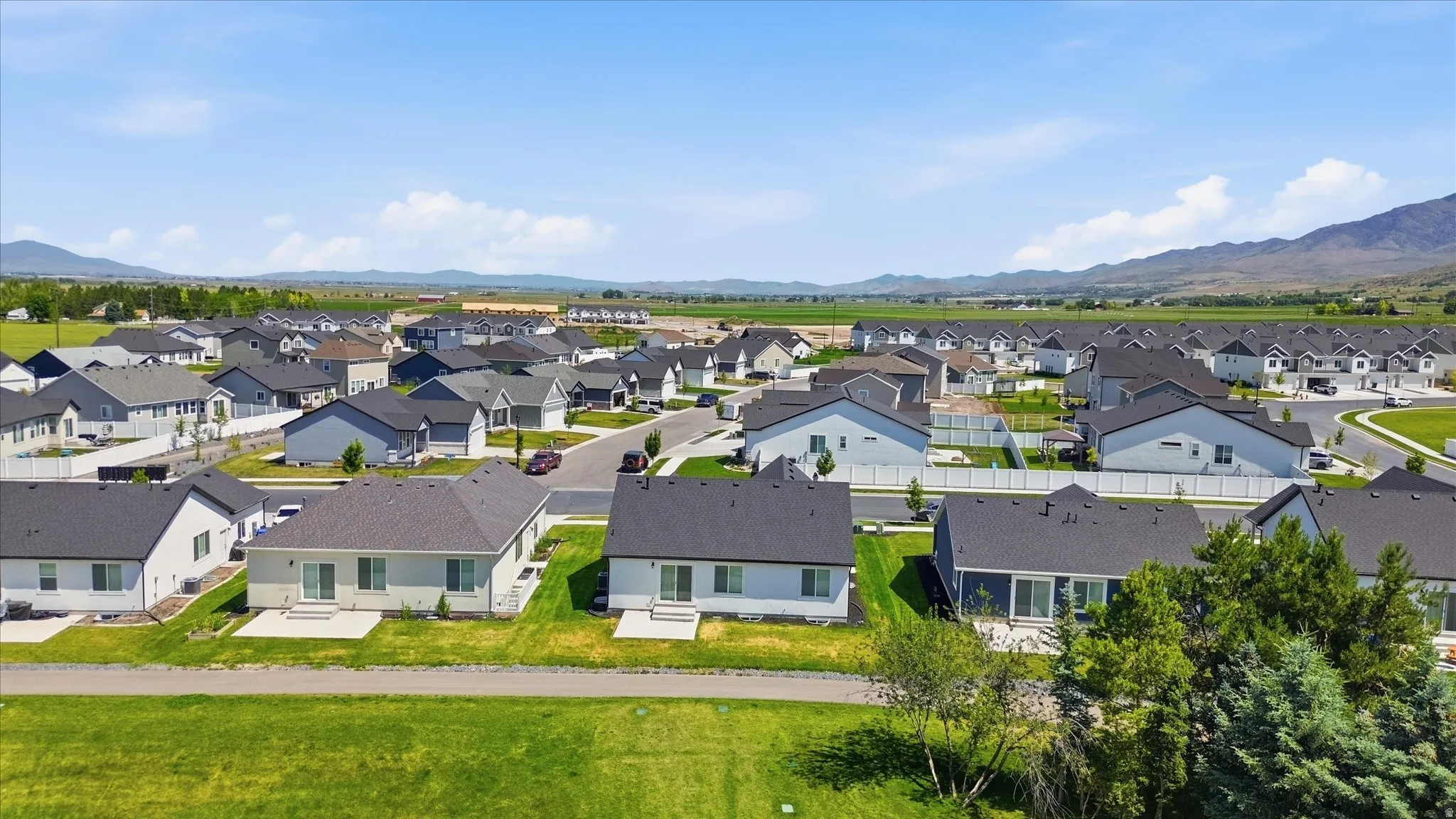 Aerial perspective of a developed residential community with dark-shingled roofs