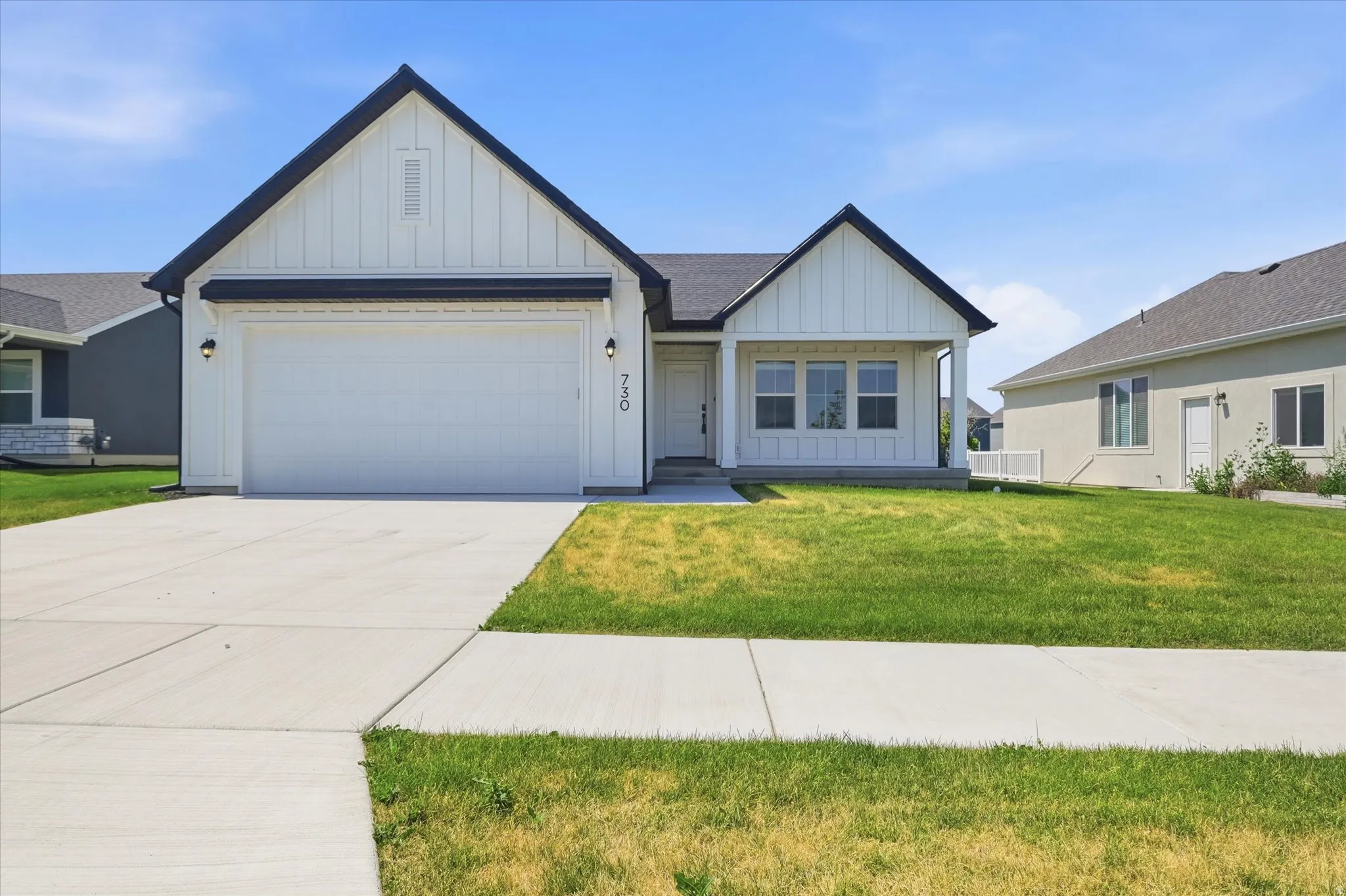 Contemporary exterior with black trim accents, a two-car garage, and a covered entry