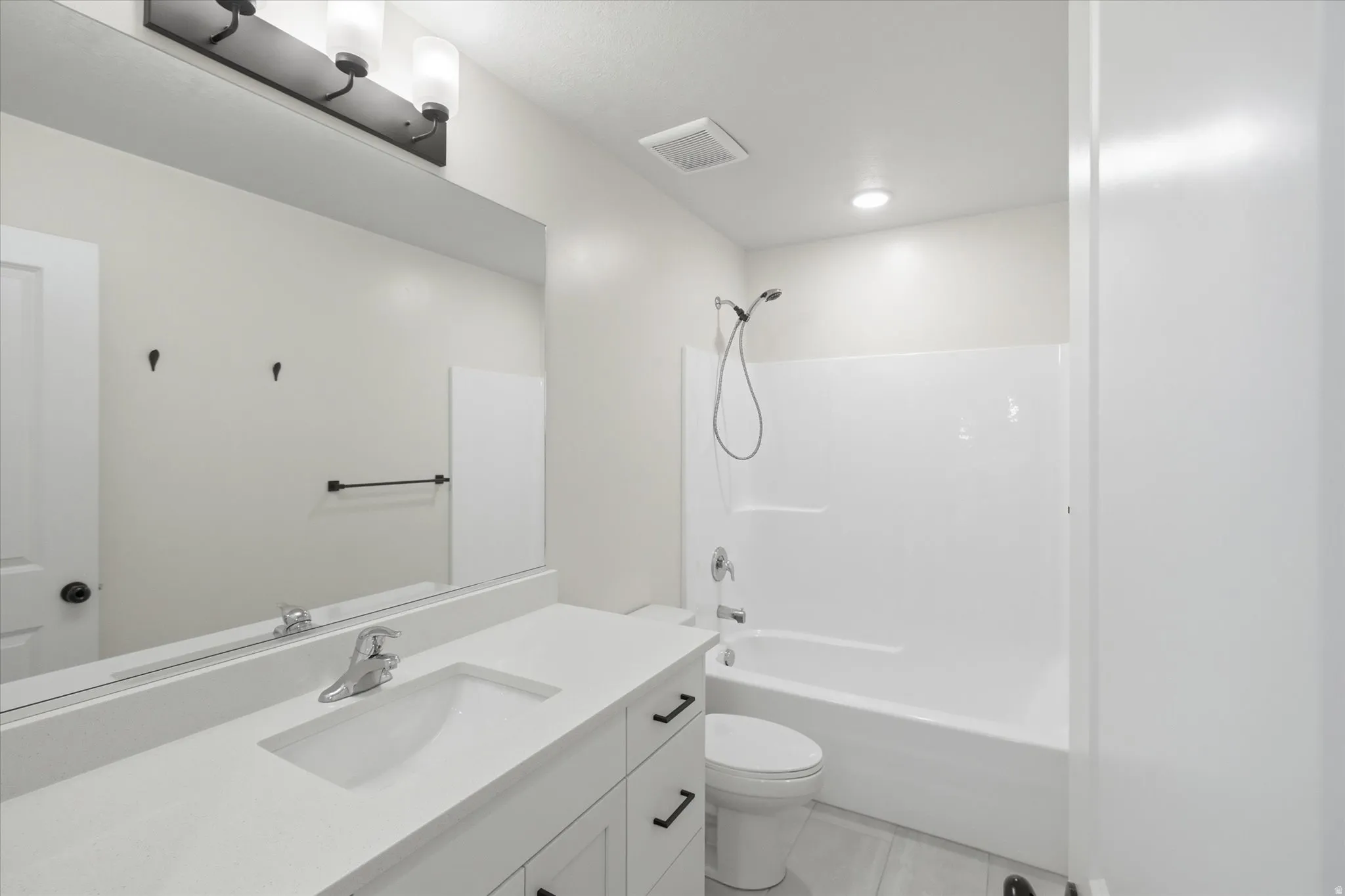 White vanity with integrated sink, chrome faucet, and black hardware