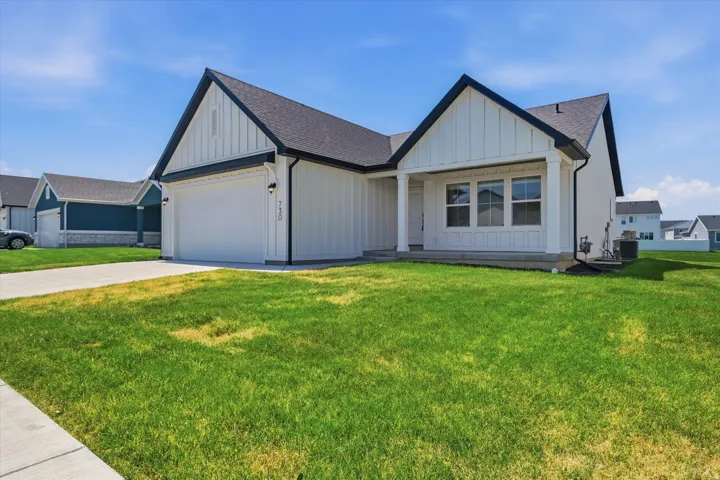 Modern farmhouse residence featuring a clean-lined exterior with board-and-batten siding, peaked gable rooflines with dark architectural shingles, and a two-car garage