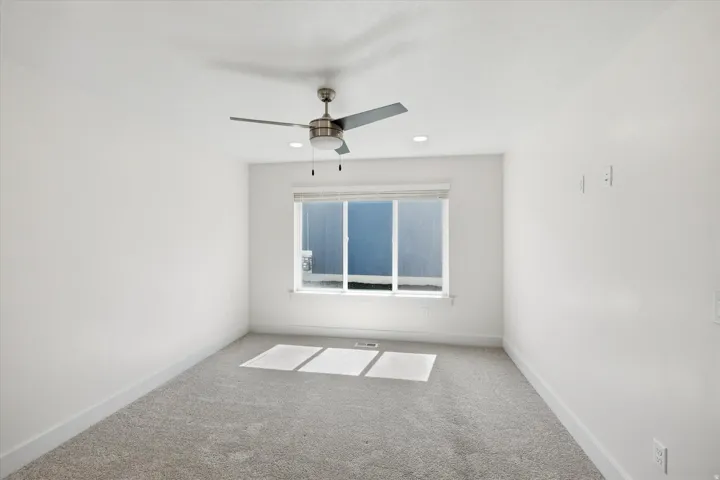 Recessed lighting, ceiling fan, window with blinds, light gray carpet, and white walls