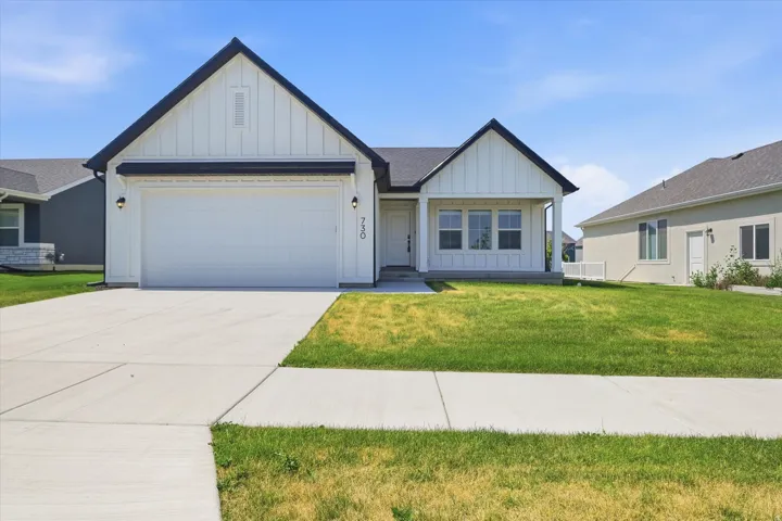 Contemporary exterior with black trim accents, a two-car garage, and a covered entry