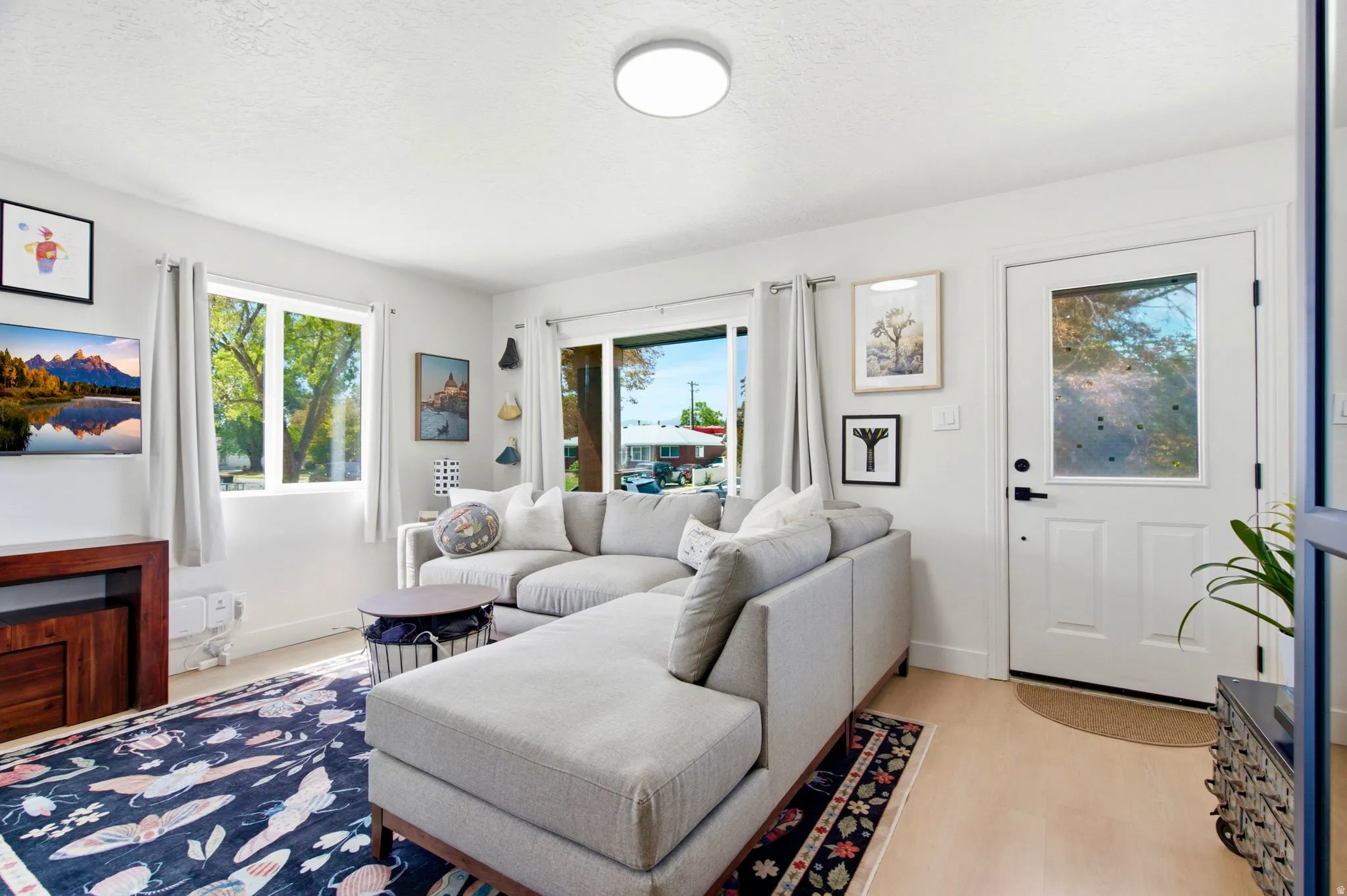 Light wood-finish flooring, white walls, and recessed lighting enhance the bright interior