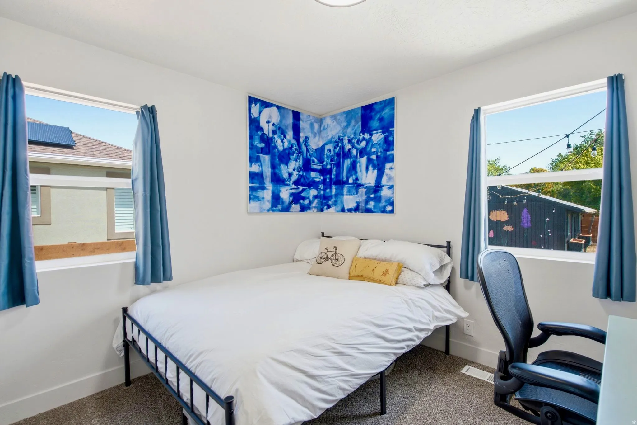 Room featuring light gray walls, carpet flooring, and two windows