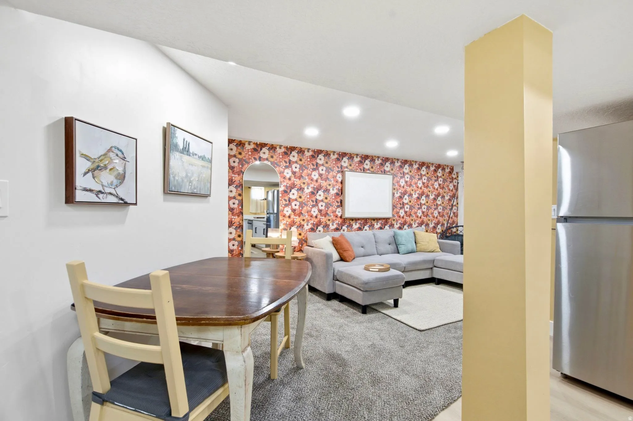 Recessed lighting illuminates the living area featuring textured carpeting