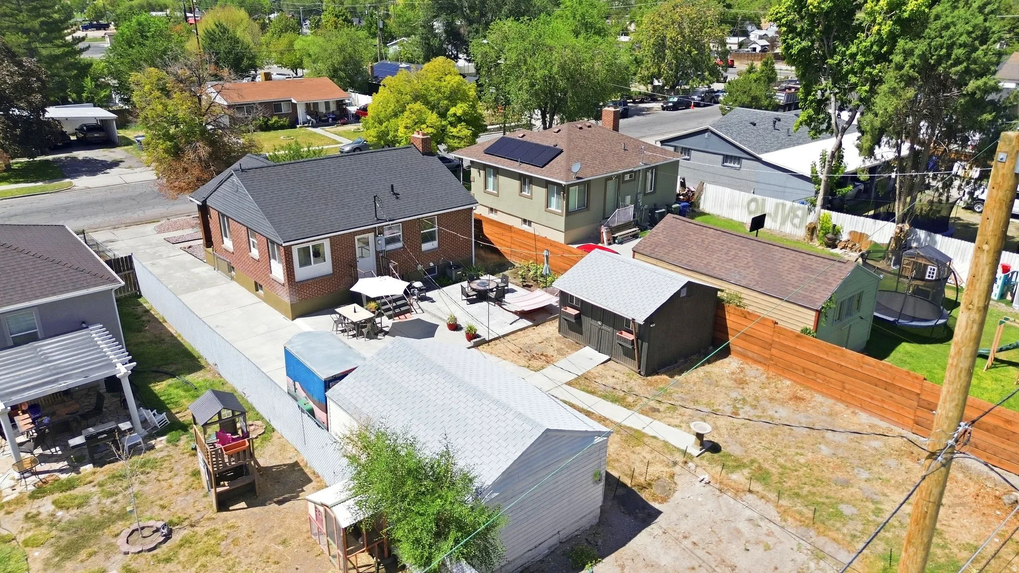 Brick exterior residence with a private driveway, concrete patio, and a detached storage shed