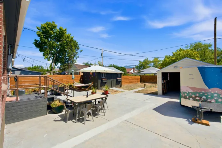 Spacious concrete patio with a raised composite deck and wood privacy fencing