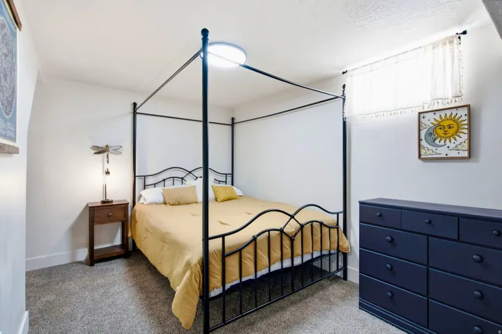 White wall finishes with a window, textured ceiling, and gray carpet flooring