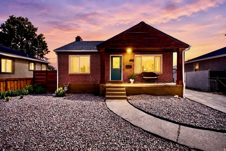Brick exterior with a covered front porch and a teal entry door