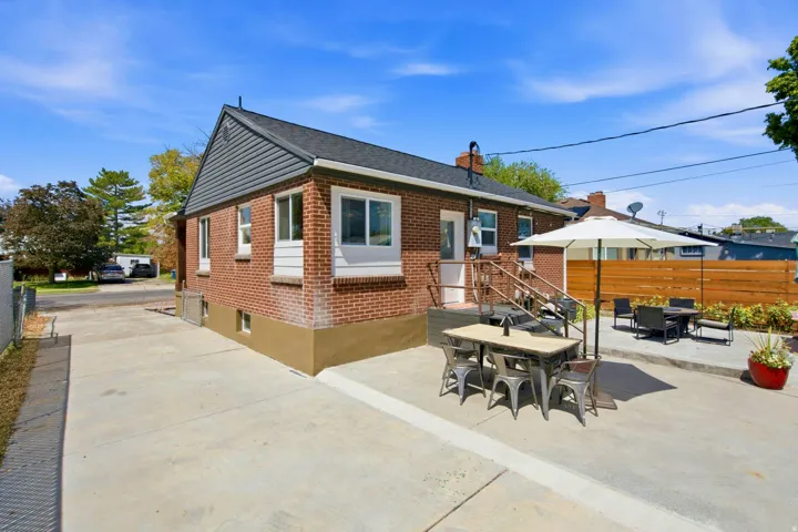 Brick exterior with dark gray siding accents and a black shingle roof