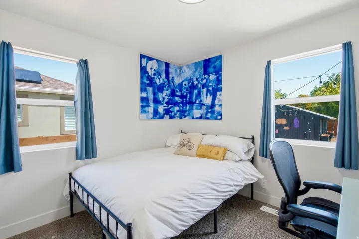 Room featuring light gray walls, carpet flooring, and two windows