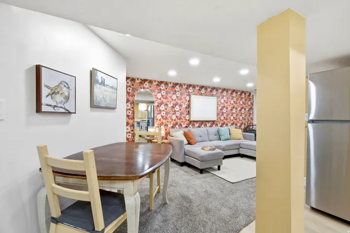 Recessed lighting illuminates the living area featuring textured carpeting