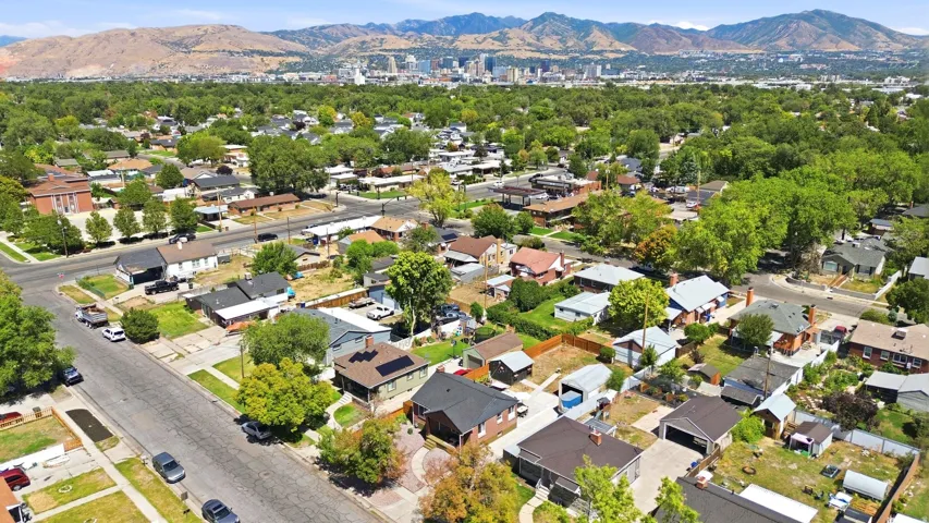 Residential neighborhood with mature trees, paved streets, and a mountainous backdrop