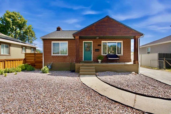 Brick exterior with a covered porch, wood-finish porch columns, and a concrete walkway