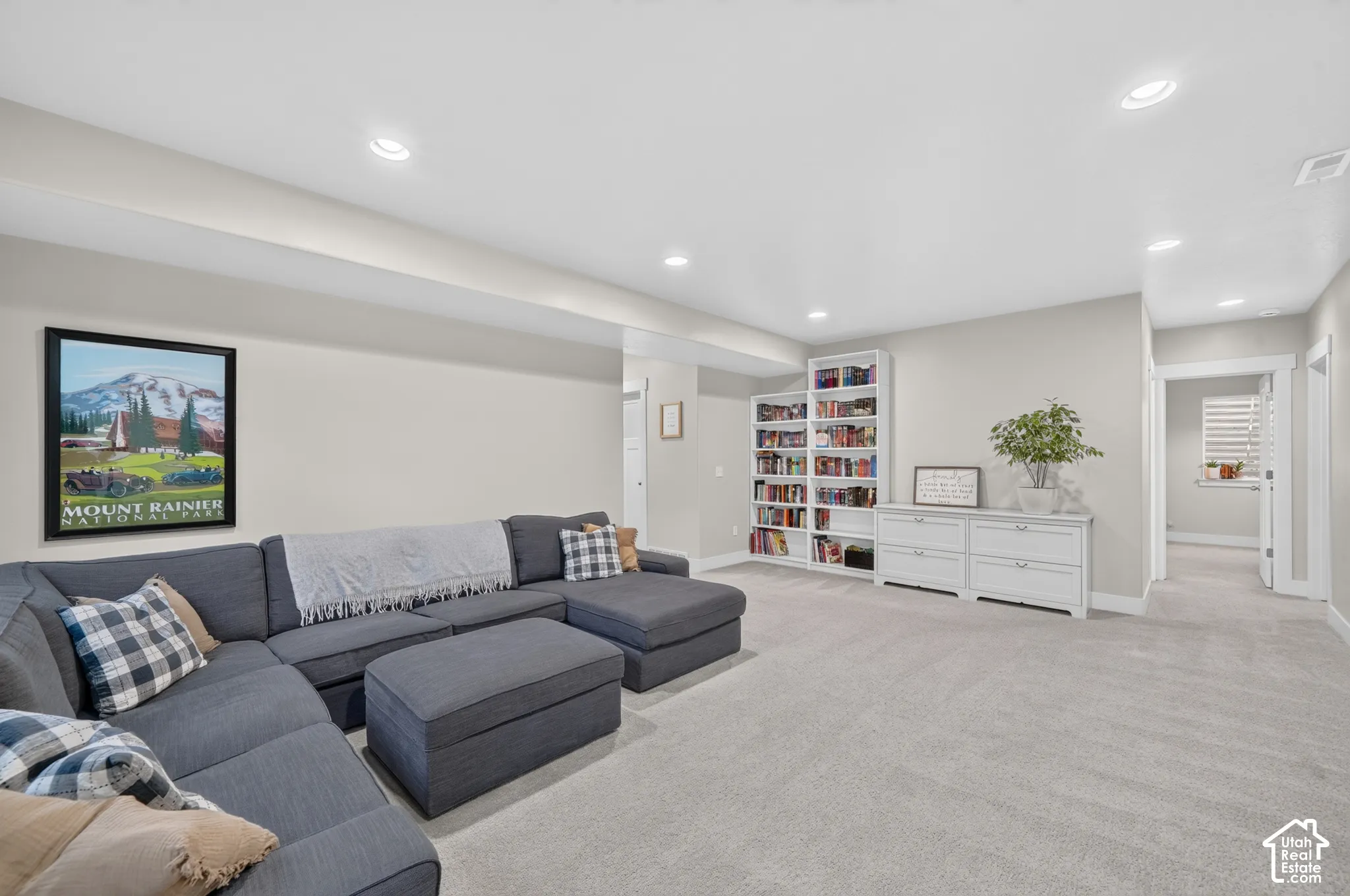 Recessed lighting, light-colored walls, carpeted flooring, built-in shelving, and a built-in storage unit