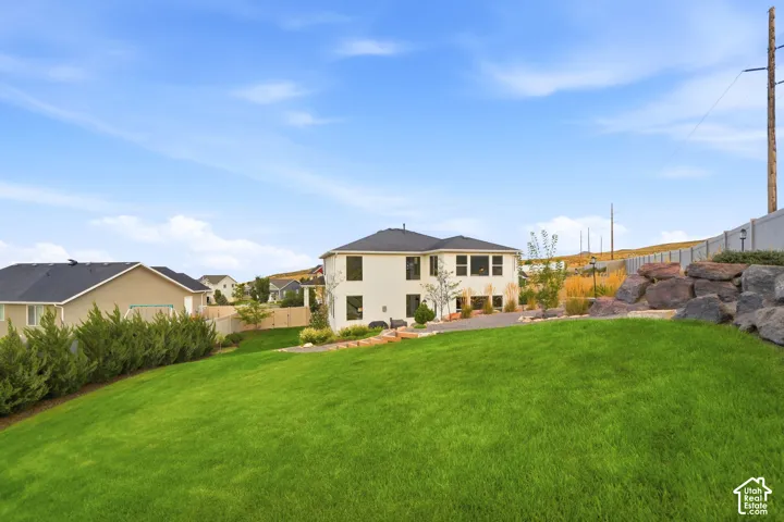 Expansive green lawn with a landscaped rock retaining wall