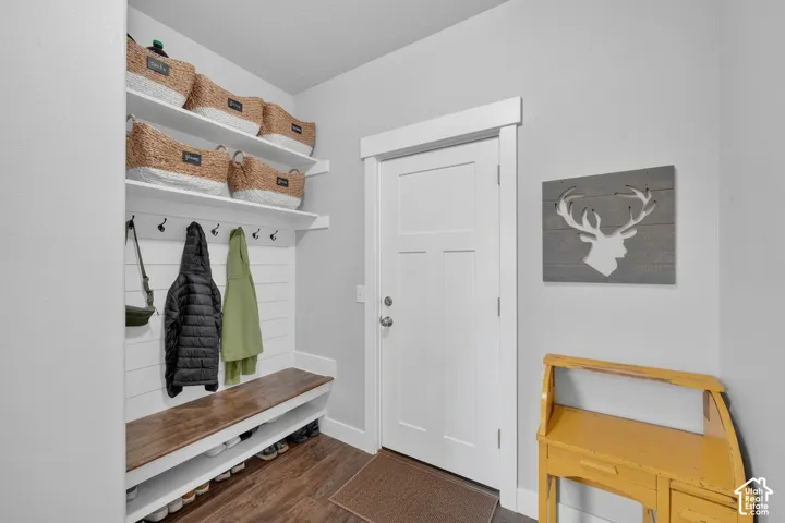 Built-in bench with wood-finish top, integrated coat hooks, and open shelving above